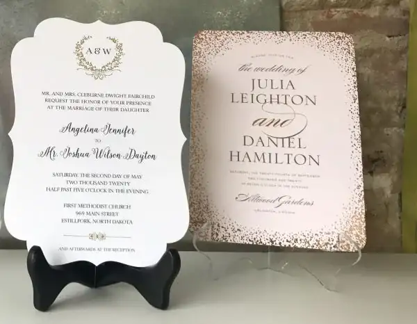 Elegant wedding invitations with monogram and rose-gold details on display stands